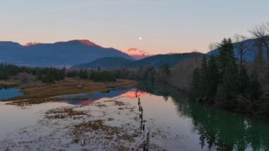 Kanada doğasında dağlar ve ağaçlarla çevrili bir göl. Sonbahar sezonu, Günbatımı Gökyüzü. Squamish, İngiliz Kolombiyası Kanada.