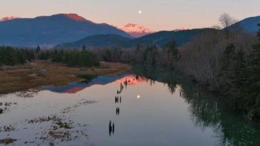 Kanada doğasında dağlar ve ağaçlarla çevrili bir göl. Sonbahar sezonu, Günbatımı Gökyüzü. Squamish, İngiliz Kolombiyası Kanada.
