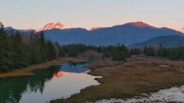 Kanada doğasında dağlar ve ağaçlarla çevrili bir göl. Sonbahar sezonu, Günbatımı Gökyüzü. Squamish, İngiliz Kolombiyası Kanada.