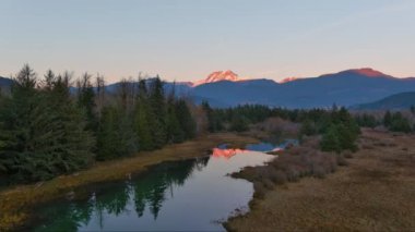 Kanada doğasında dağlar ve ağaçlarla çevrili bir göl. Sonbahar sezonu, Günbatımı Gökyüzü. Squamish, İngiliz Kolombiyası Kanada.