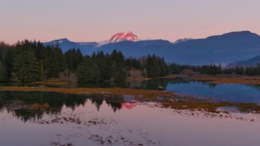 Kanada doğasında dağlar ve ağaçlarla çevrili bir göl. Sonbahar sezonu, Günbatımı Gökyüzü. Squamish, İngiliz Kolombiyası Kanada.
