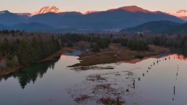 Kanada doğasında dağlar ve ağaçlarla çevrili bir göl. Sonbahar sezonu, Günbatımı Gökyüzü. Squamish, İngiliz Kolombiyası Kanada.