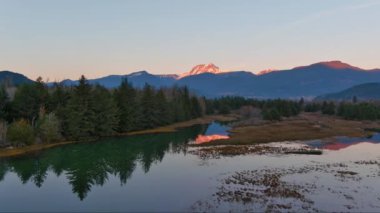 Kanada doğasında dağlar ve ağaçlarla çevrili bir göl. Sonbahar sezonu, Günbatımı Gökyüzü. Squamish, İngiliz Kolombiyası Kanada.