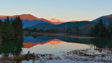 Kanada doğasında dağlar ve ağaçlarla çevrili bir göl. Sonbahar sezonu, Günbatımı Gökyüzü. Squamish, İngiliz Kolombiyası Kanada.