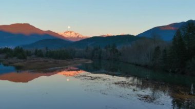 Kanada doğasında dağlar ve ağaçlarla çevrili bir göl. Sonbahar sezonu, Günbatımı Gökyüzü. Squamish, İngiliz Kolombiyası Kanada.