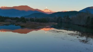 Kanada doğasında dağlar ve ağaçlarla çevrili bir göl. Sonbahar sezonu, Günbatımı Gökyüzü. Squamish, İngiliz Kolombiyası Kanada.