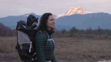 Anne ve bebek Kanada doğasında yürüyüş yapıyor. Sonbahar sezonu, Günbatımı. Squamish, Britanya Kolombiya Kanada 'sı. Yavaş Hareket