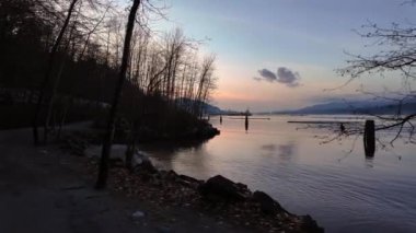 Okyanus kıyısında bir şehir parkında Rocky Shore. Günbatımı Gökyüzü. Barnet Marine Park, Burnaby, Vancouver, BC, Kanada. Yavaş çekim