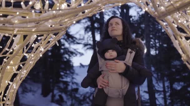 Madre Con Adorabile Bambino Carrier Guardando Luci Natale Stagione Invernale — Video Stock