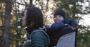 Sırt çantasındaki Sevimli Bebek 'le Anne Yürüyüşü. Etrafa bakıyorum. Kış mevsimi, Günbatımı. Squamish, İngiliz Kolombiyası Kanada.