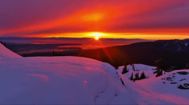 Karlı, Rocky Dağı Tepesi, Parlayan Kızıl Gökyüzü. Okyanus ve Ufuk 'un Manzarası. Hava sineması. British Columbia, Kanada.