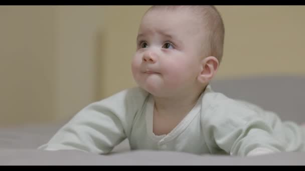 Yatakta Oturan Kaşlarını Çatan Dik Dik Bakan Bir Bebek Yaklaşın — Stok video
