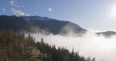Squamish Vadisi 'nde ağaçların, dağların ve alçak bulutların havadan görünüşü. Mavi Gökyüzü, Güneşli Gün. MÖ. Squamish Kanada.