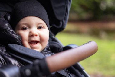 Bebek çocuk dışarıda parkta bebek arabasında oturuyor. Burnaby, Vancouver, BC, Kanada.