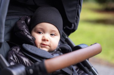 Bebek çocuk dışarıda parkta bebek arabasında oturuyor. Burnaby, Vancouver, BC, Kanada.