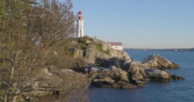 Sahne Rocky Okyanus Kıyısı, Deniz feneri ve Ağaçlar. Güneşli Günbatımı. Deniz Feneri Parkı, Batı Vancouver, İngiliz Kolombiyası, Kanada.