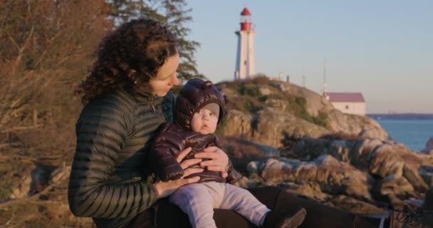 Mãe Bebê Menino Sentado Rock Pela Costa Oceânica Cênica Farol — Vídeo de Stock