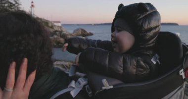Baby Boy, okyanus kıyısında Rock 'ta doğa yürüyüşü yapan bir gemide annesiyle oynaşıyor. Fener Parkı, Batı Vancouver, BC, Kanada.