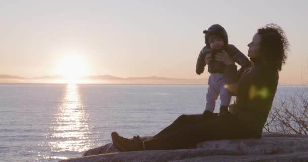 Matka Chlapeček Sedí Skále Malebného Mořského Pobřeží Skákání Dětí Západ — Stock video