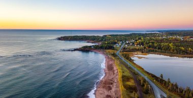 Atlantik Okyanusu 'nun doğu kıyısında canlı bir manzara. Yol ve kasabayla. Gündoğumu Quebec, Kanada.