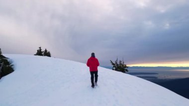 Karlı Dağda Ağaçlarla Maceracı Yürüyüşçü. Bulutlu Günbatımı Gökyüzü. British Columbia, Kanada.
