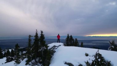 Karlı Dağda Ağaçlarla Maceracı Yürüyüşçü. Bulutlu Günbatımı Gökyüzü. British Columbia, Kanada.