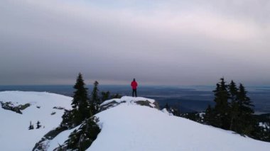 Karlı Dağda Ağaçlarla Maceracı Yürüyüşçü. Bulutlu Günbatımı Gökyüzü. British Columbia, Kanada.