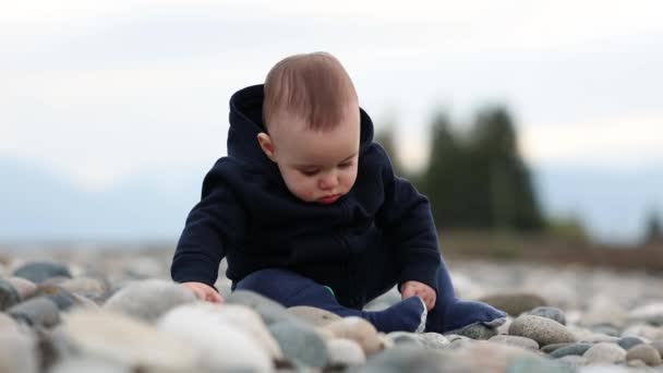 可爱的小男孩坐在河边的落基海岸上 夕阳西下春季来临加拿大不列颠哥伦比亚省Chilliwack — 图库视频影像
