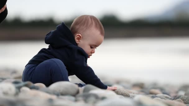 Adorable Bebé Sentado Rocky Shore Junto Río Puesta Sol Temporada — Vídeo de stock