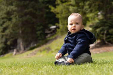 Bebek dışarıda, yemyeşil çimlerde oynuyor. Kanada doğasında. British Columbia, Kanada.