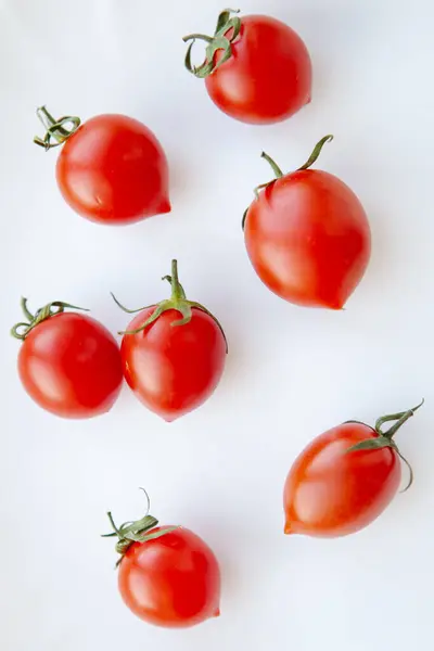 Tahtadaki kiraz domatesleri ve yeşil yapraklar 