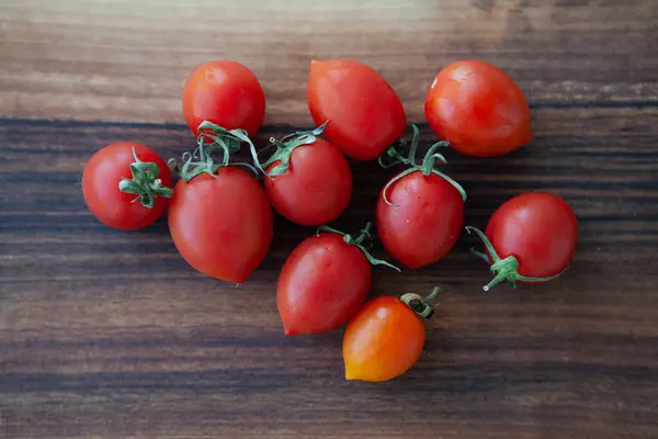 Tahta masadaki kiraz domatesleri.