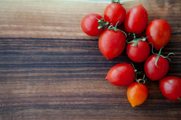 Tahta masadaki kiraz domatesleri.