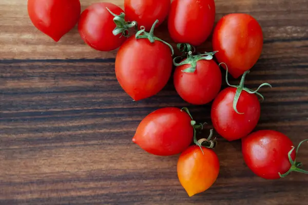 Tahta masadaki kiraz domatesleri.