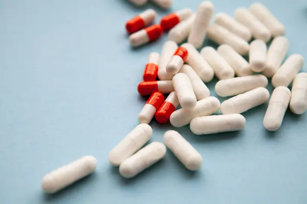Yakın plan - beyaz arka planda bir yığın hap. Sağlık ve sağlık hizmetleri kavramı. şeffaf kapsül