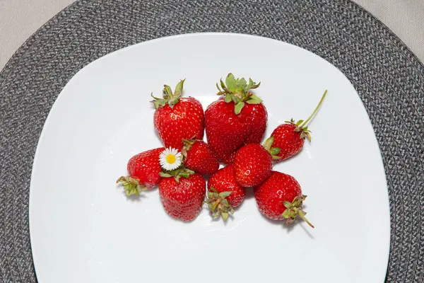 Beyaz bir tabakta, arka planda beyaz çilekler..