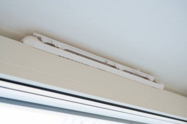 Modern pencere çerçevesinde plastik havalandırma. Bir pencerenin üzerine monte edilmiş plastik havalandırma ızgarası, konut veya ofis binalarında pasif hava akışı için kullanılır..