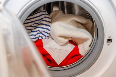 Çamaşırhanede kullanılan renk yakalayıcı çarşafı. Çamaşır makinesinin variline kırmızı ve beyaz çamaşırların yanına konan renk yakalayıcı çarşafları yıkama sırasında renk kanamasını ve boya bulaşmasını önler..