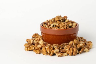 Beyaz arka planda kabuklu ceviz kabuğu, dağınık çekirdekler, izole, gevrek ve besleyici atıştırmalıklar, sağlıklı organik yiyecekler, yüksek proteinli vejetaryen malzemeler, soyulmuş ceviz parçaları.