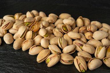 Siyah desenli arka plan, üst görünüm, kıtır fındık, lezzetli ve besleyici aperatif, sağlıklı organik gıda, yüksek proteinli vejetaryen malzeme, kabuklu fıstık. 