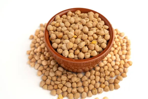 Beyaz arka planda bir kasedeki nohutlar, birçok izole edilmiş, üst görünüm, çiğ baklagiller, sağlıklı organik yiyecekler, yüksek proteinli vejetaryen malzemeler, besleyici kuru bezelyeler, tarım hasadı, yakın çekim makrosu.