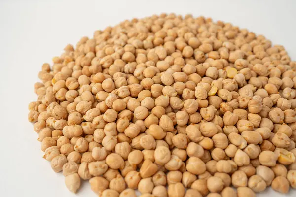 Birçok nohut beyaz bir zemin üzerine dağılmış, izole, üst görünüm, çiğ baklagiller, sağlıklı organik yiyecekler, yüksek proteinli vejetaryen malzemeler, besleyici kuru bezelyeler, tarım hasat