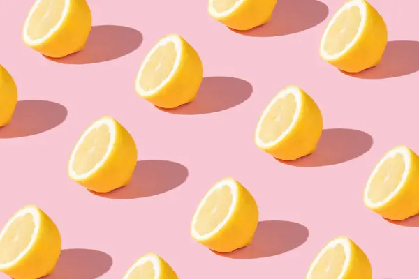 Parlak açık pembe arka planda sarı limon dilimli son moda güneş ışığı deseni. Minimum yaz konsepti.