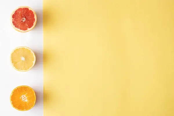 Beyaz ve sarı arka planda portakal ve greyfurt dilimi. Minimum düzlük.