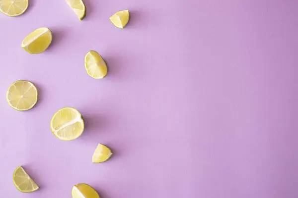 Parlak mor arka planda limon dilimi kopyalanmış. Minimum yaz yiyecekleri konsepti.