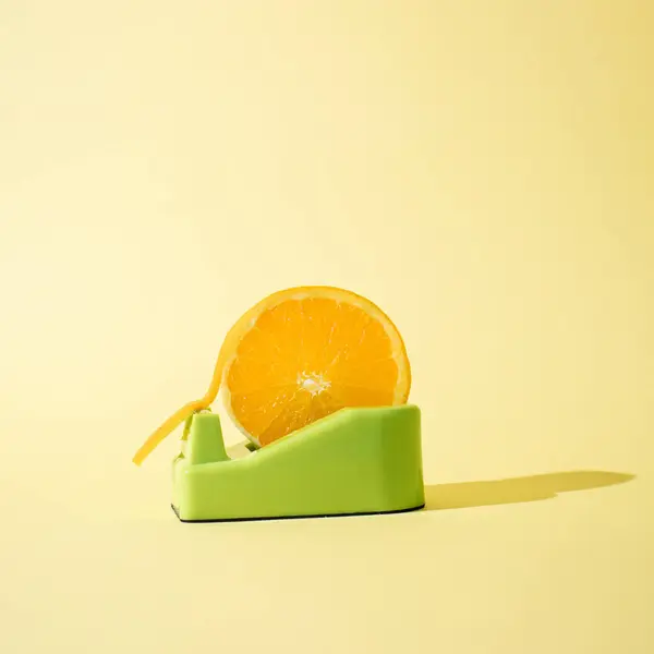 Parlak sarı arka planda İskoç bantlı portakal dilimi. Yaratıcı gıda kavramı.