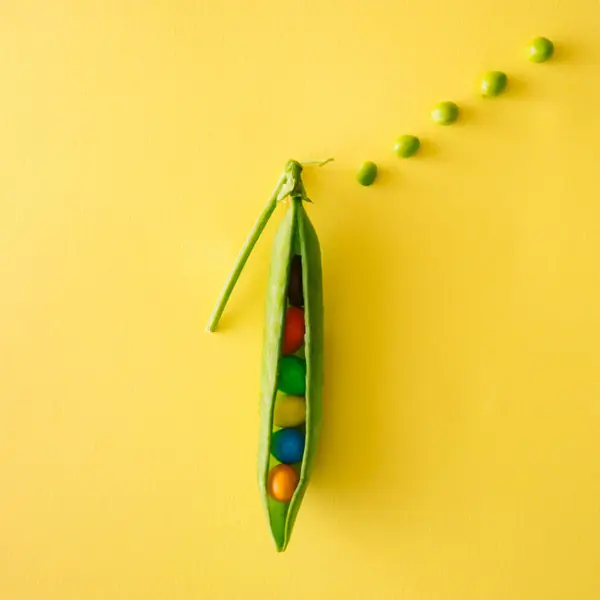 Bezelye ve rengarenk şekerlemelerle yapılmış yaratıcı yiyecek konsepti. Düz yatıyordu.