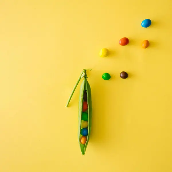 Bezelye ve rengarenk şekerlemelerle yapılmış yaratıcı yiyecek konsepti. Düz yatıyordu.