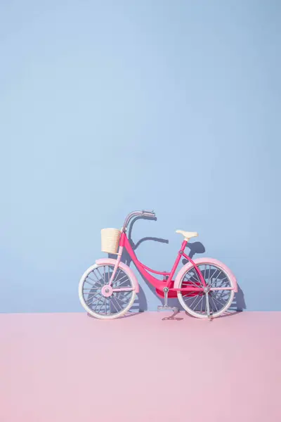 Pastel pembe ve mavi arka planda bej sepetli bisiklet. Yaratıcı minimum konsept.