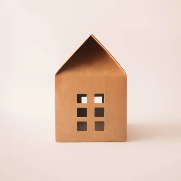 Beyaz arka planda güneşli kahverengi kağıt ev. En az yaratıcı kavram.
